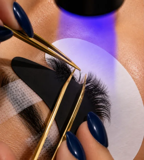 UV lash extensions being applied and cured under a UV lamp